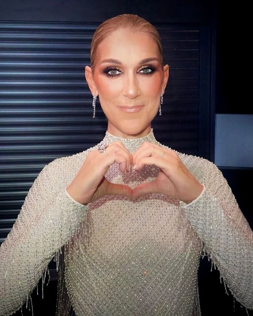 Celine Dion poses with her hands shaped in a heart