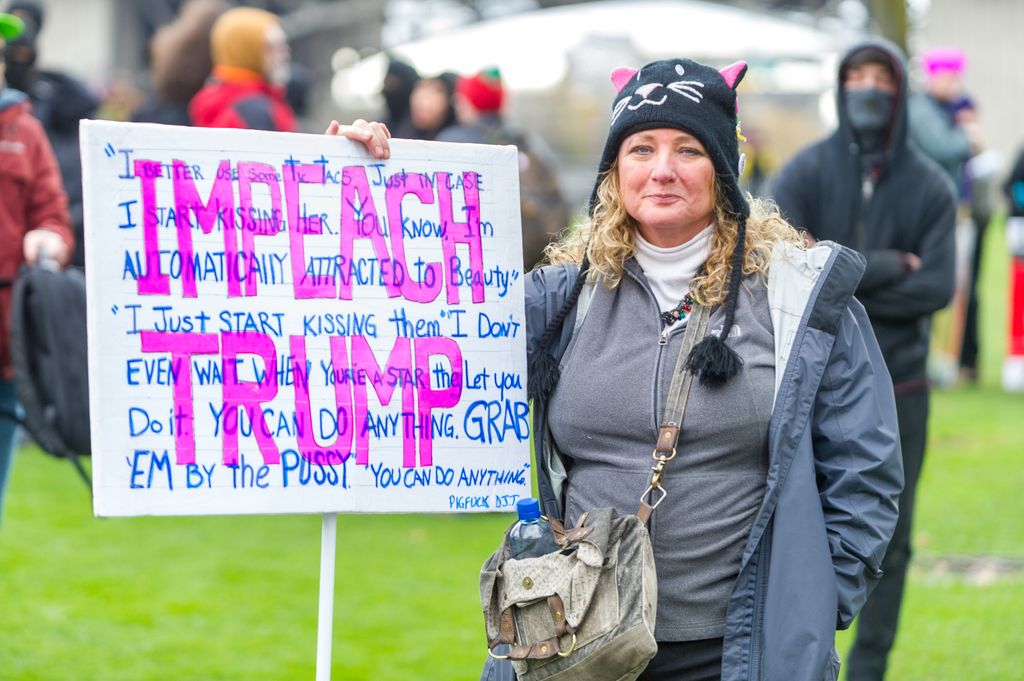 A woman alludes to a direct quote of the Hollywood Access Tape of then candidate Donald Trump at Portland's National March for Impeachment on January 20, 2018, in downtown Portland, OR