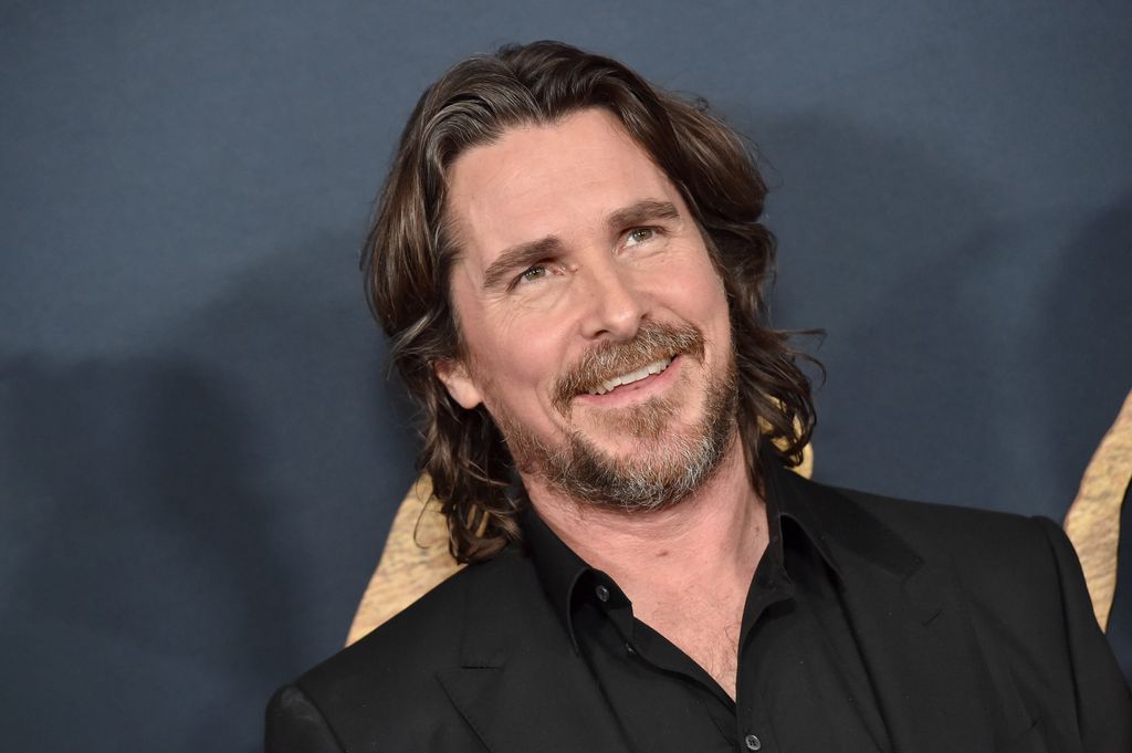 Christian Bale smiling at premiere for The Pale Blue Eye while smiling at cameras
