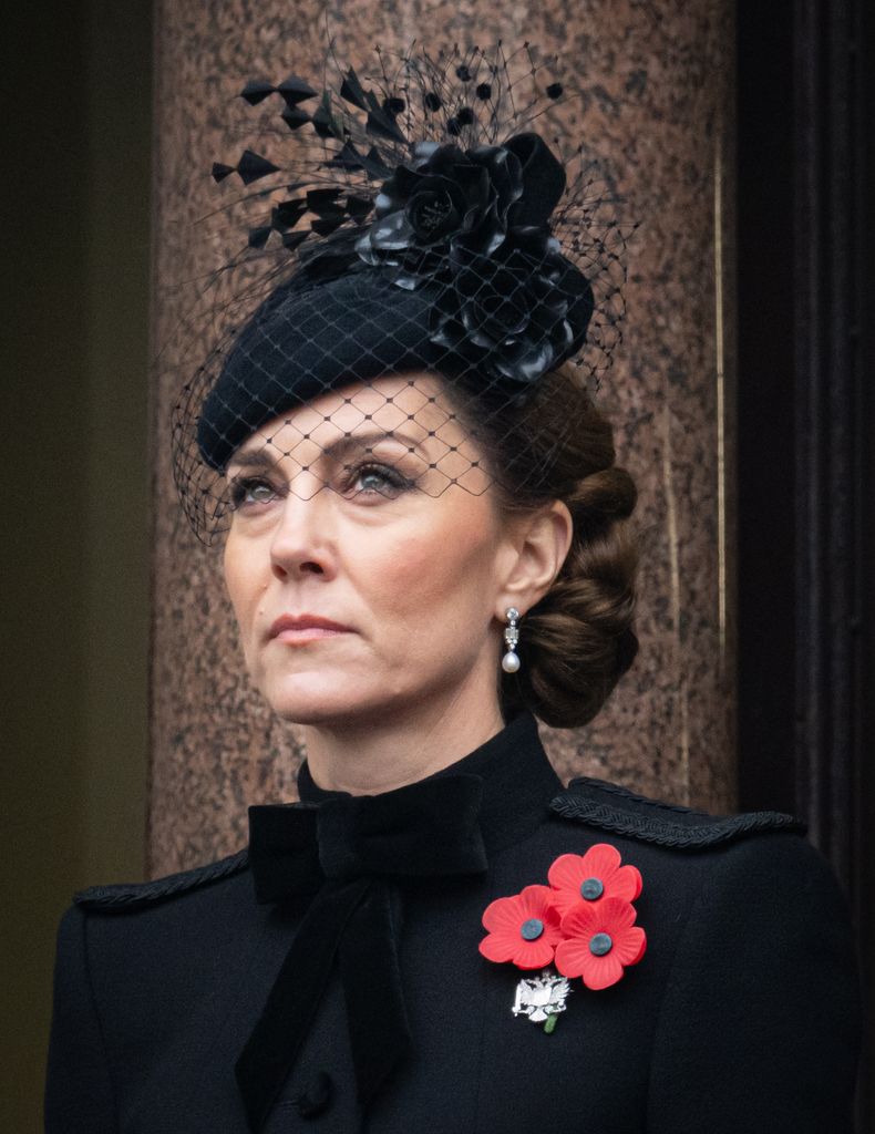 Princess of Wales (Kate Middleton) wears a black fascinator with netting, adorned with red poppies. Her poised expression and attire are reminiscent of traditional British elegance.