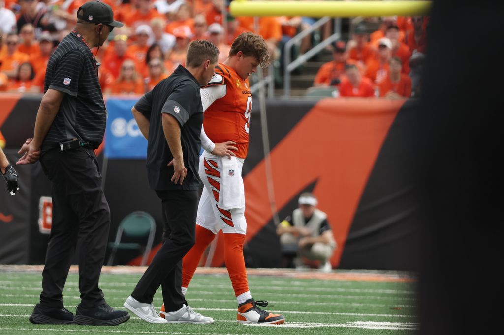 Joe Burrow #9 of the Cincinnati Bengals is helped off the field following an injury in the second quarter of the game against the Jacksonville Jaguars at Paycor Stadium on September 14, 2025 in Cincinnati, Ohio