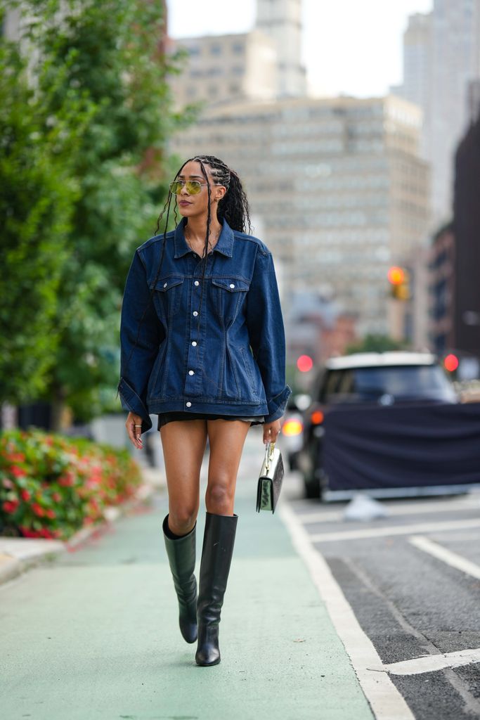 Fashion week guest wearing short fitted denim jacket over mini dress 