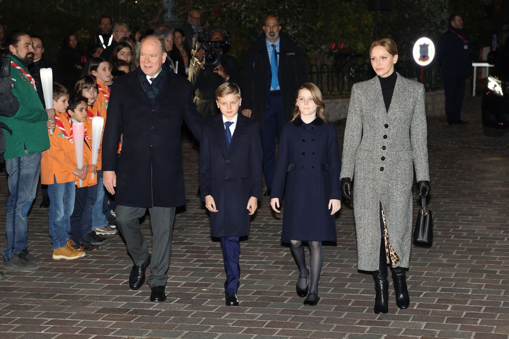 Princess Gabriella in navy coat walking outside at night between parents