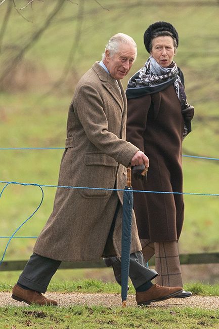 king charles arriving at church in sandringham with princess anne wearing brown coat and silk scarf