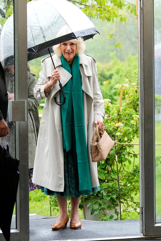 Queen Camilla carrying umbrella over head