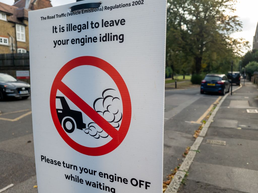 A sign near a London school warning drivers not to leave their engine idling while waiting or parked