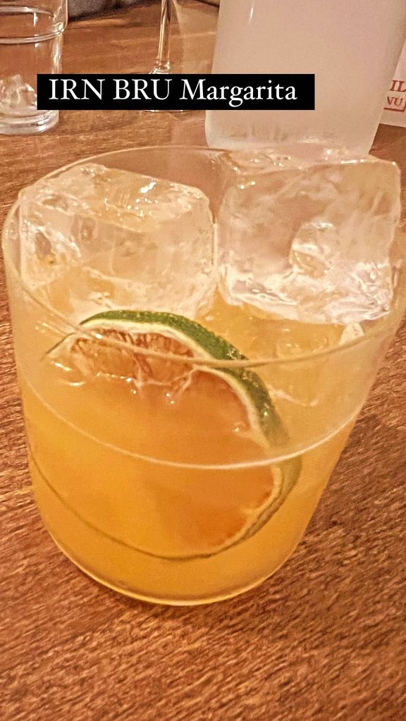 A photo of a short orange cocktail