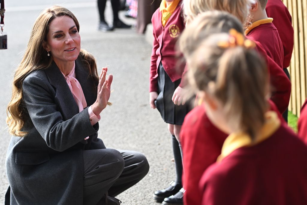 Kate crouching down to speak with school kids