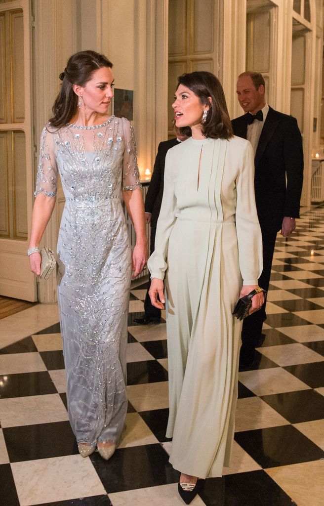 Catherine and Anne Llewellyn walking through hall in dresses