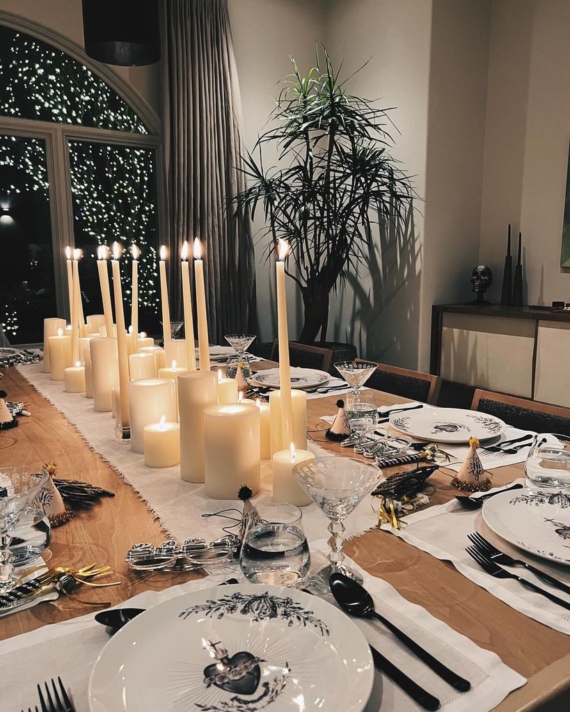 dining table with runner, placemats, plates, cutlery, candles