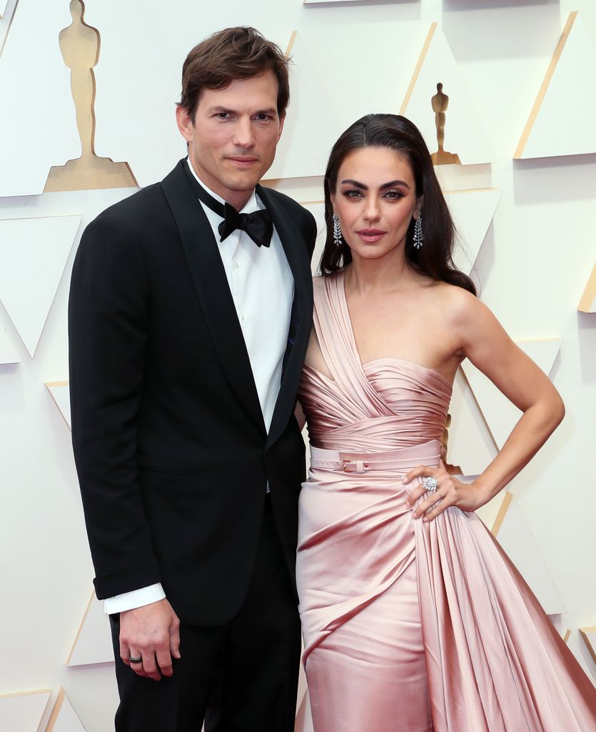 Mila Kunis and Ashton Kutcher pose together on the Oscars red carpet