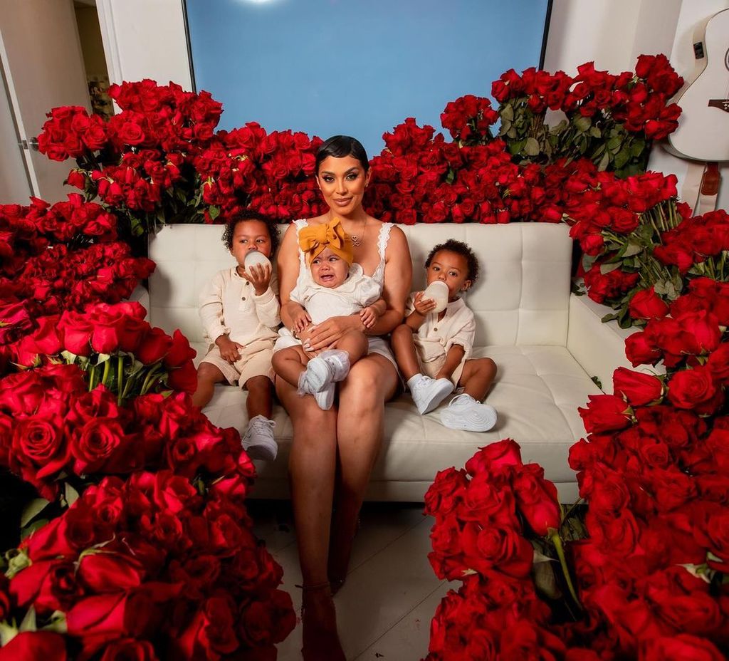 Abby de la Rosa sits with her sons and daughter Beautiful surrounded by red roses