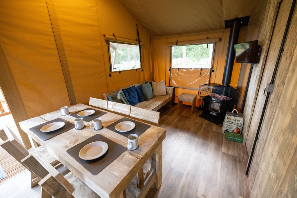 inside tent with sofa, dining room table and TV
