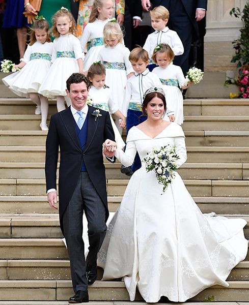 Jack Brooksbank in a suit and Princess Eugenie in bridal gown with children in white behind them