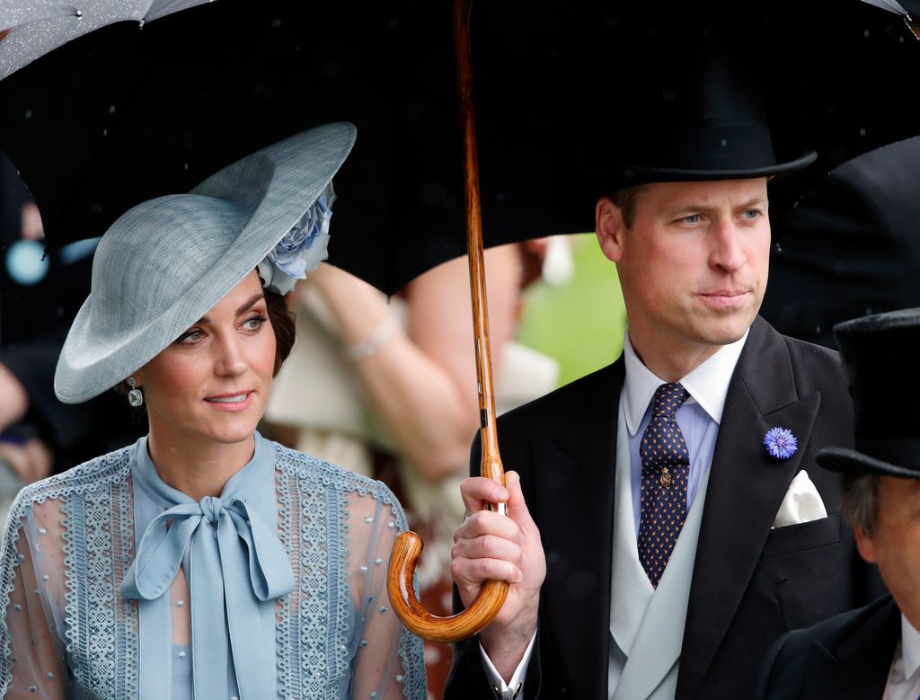 Princess Kate and Prince William shelter under an umbrella as they attend day one of Royal Ascot at Ascot Racecourse on June 18, 2019 in Ascot, England.