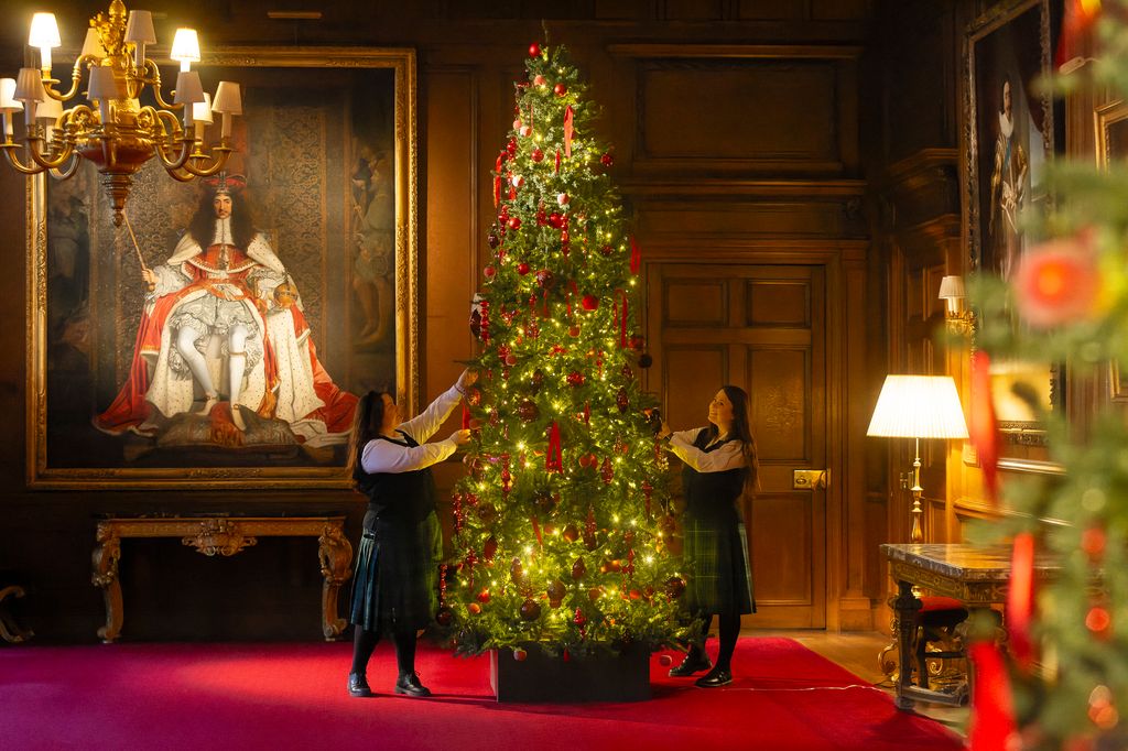 people decorating tree in royal home