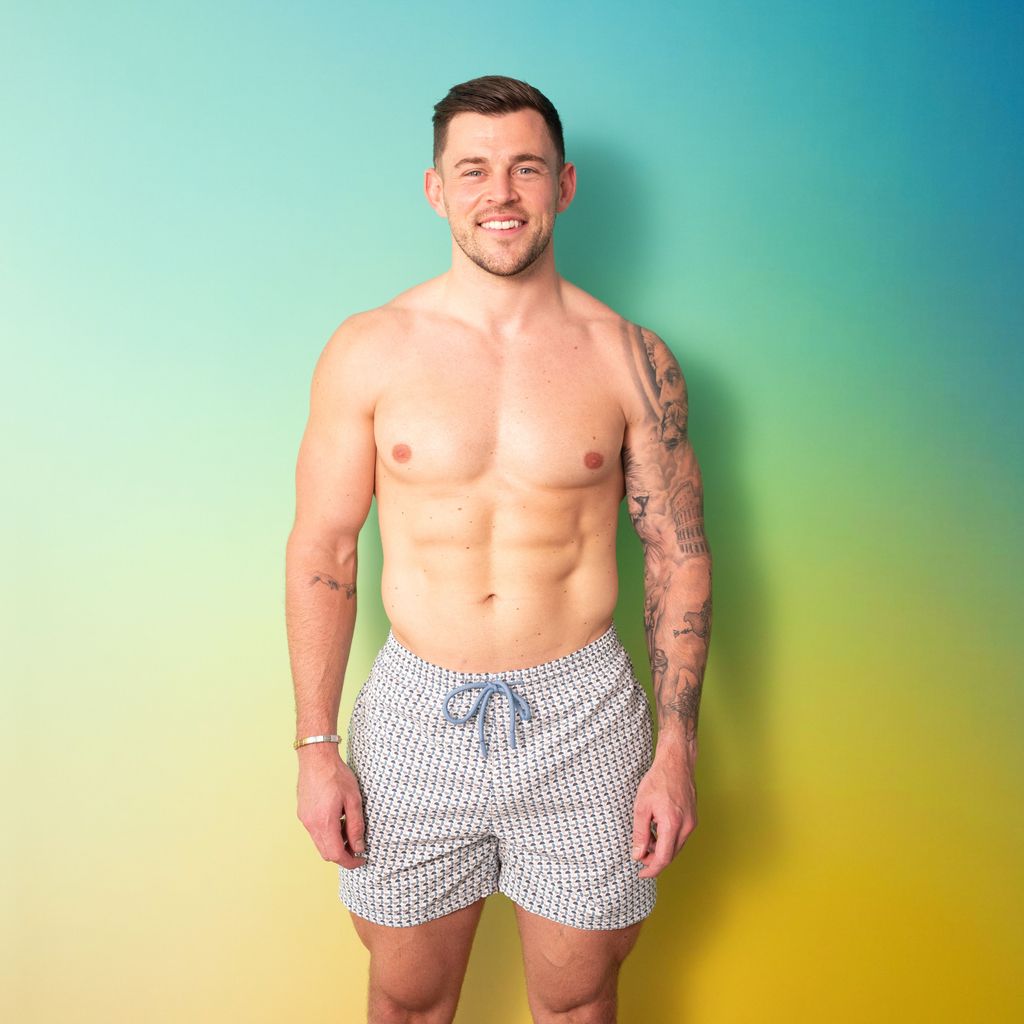Giorgio Russo secoue aux seins nus dans une paire de shorts de natation gris