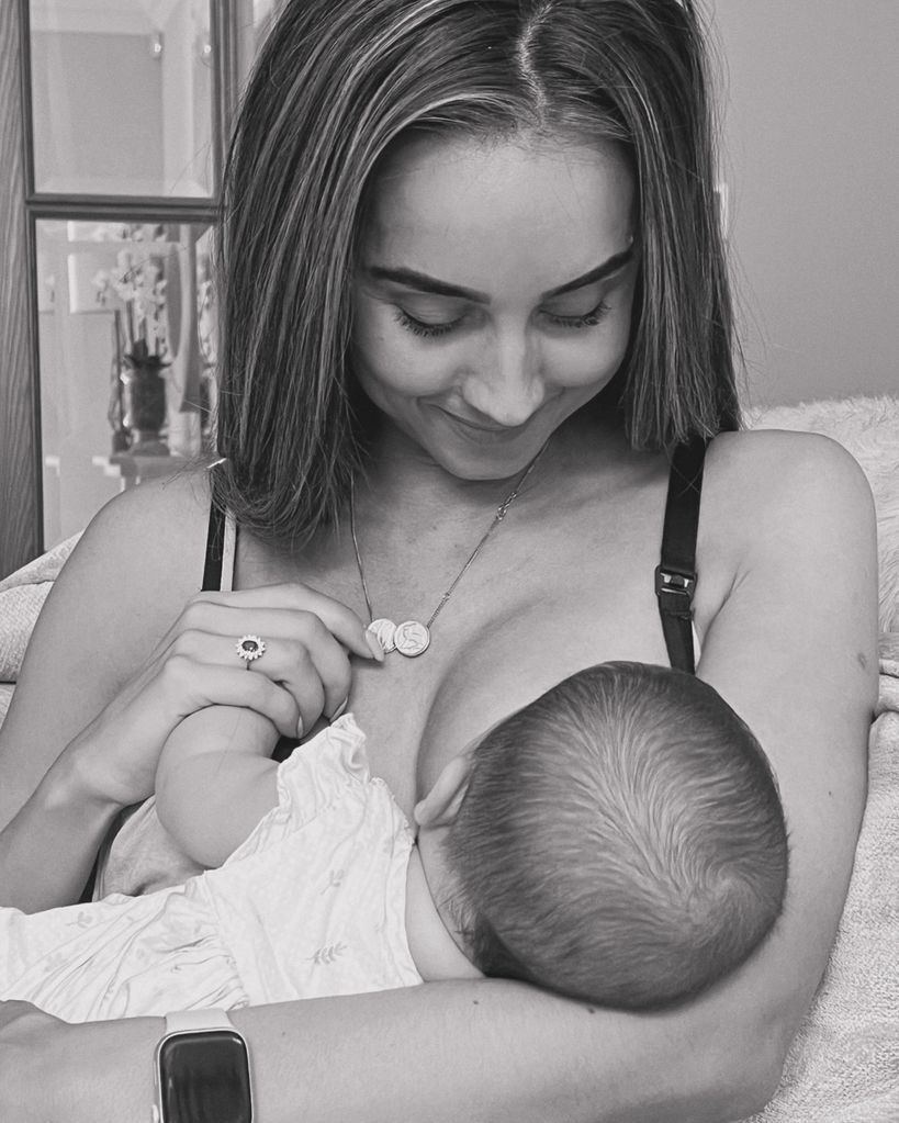 woman breastfeeding baby daughter at home