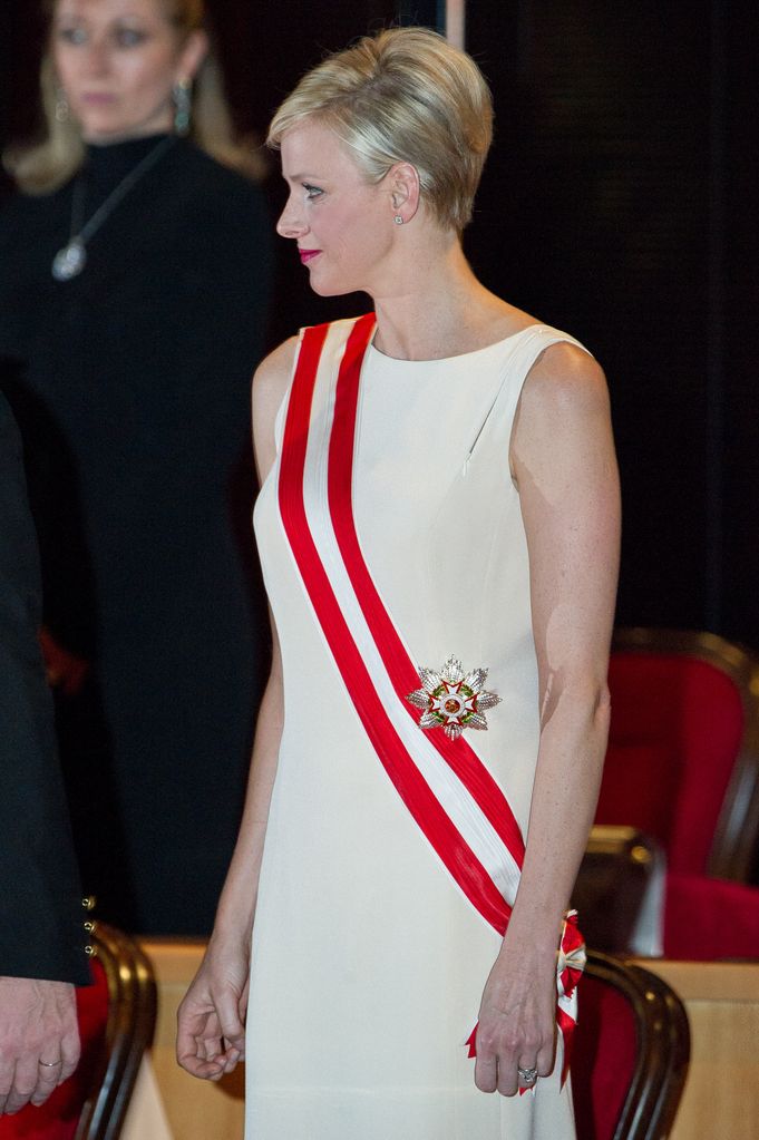 Princess Charlene in white dress with red sash