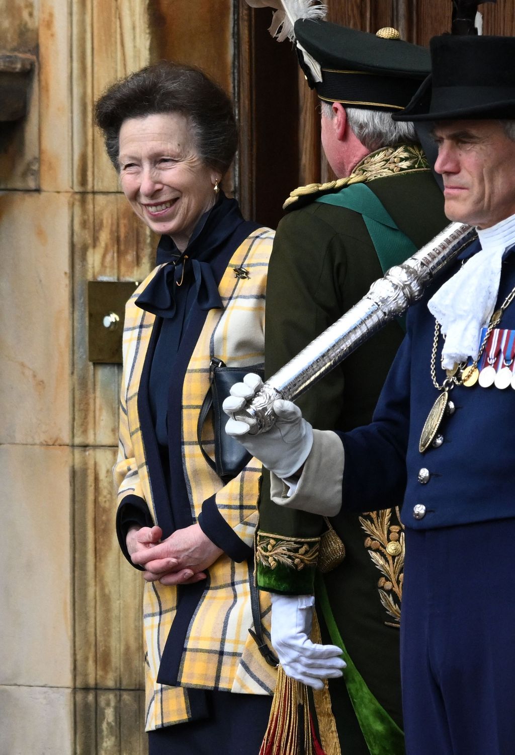 Princess Anne smiling dressed in tartan