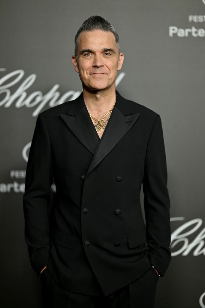 Robbie Williams smiling at a press photo opportunity