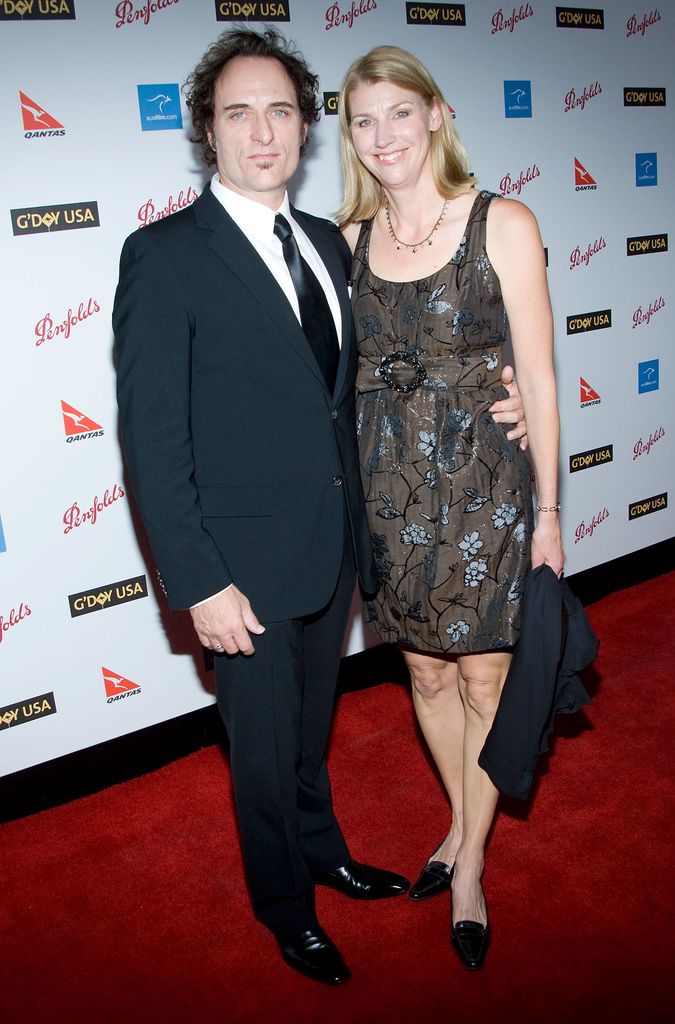 Kim Coates se tient à côté de sa femme Diana et porte un costume noir et une cravate sur le tapis rouge.