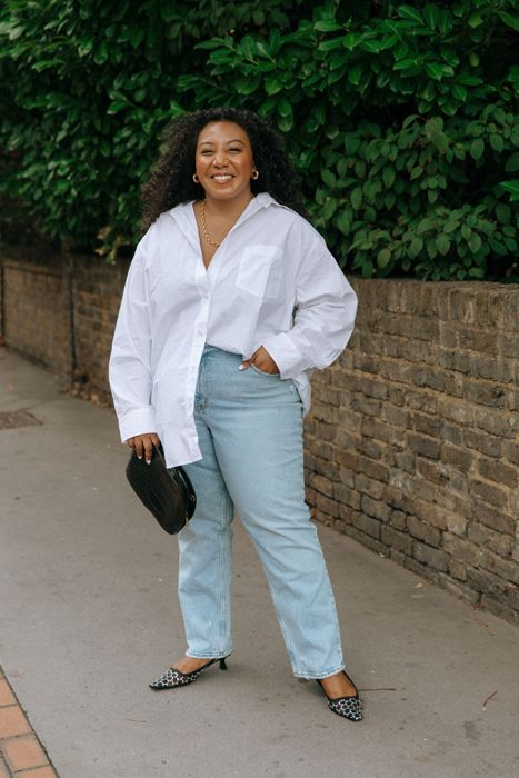Nicole Ocran wearing a white shirt and blue jeans smiling at the camera