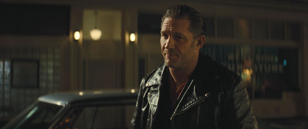 close-up man in leather jacket in street at night