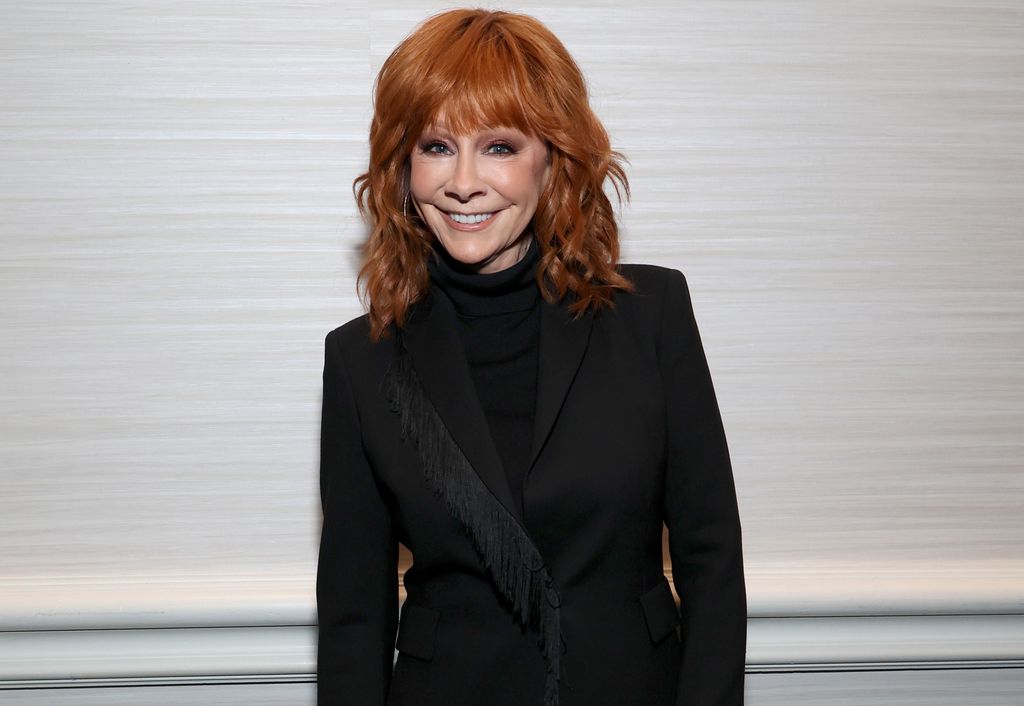 reba mcentire wearing all black and smiling for camera