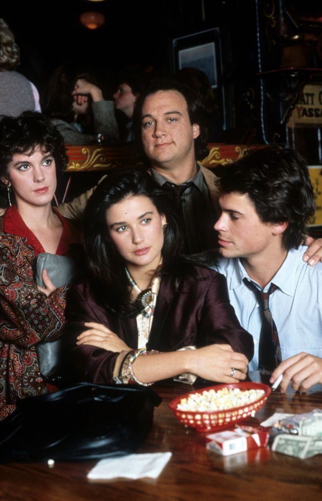 Demi Moore in a daze as Rob Lowe looks at her in a scene from the film 'About Last Night...', 1986. Behind are Elizabeth Perkins and James Belushi