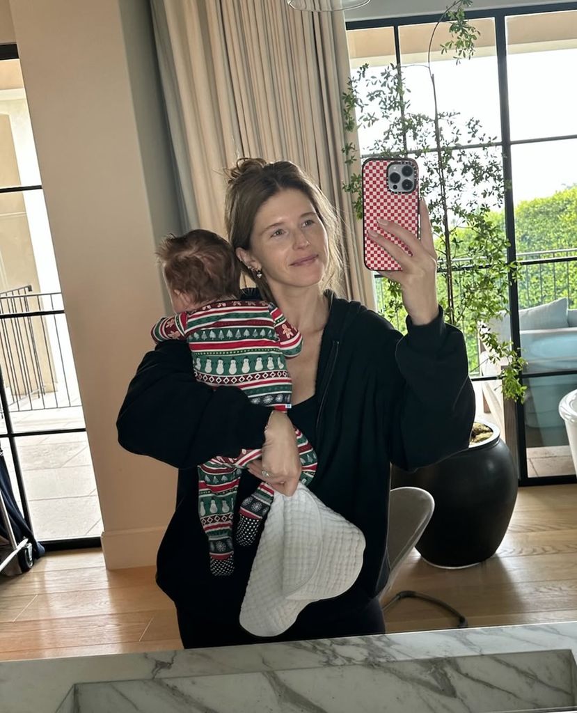 Katherine Schwarzenegger holding baby Ford while taking a selfie in the mirror at home