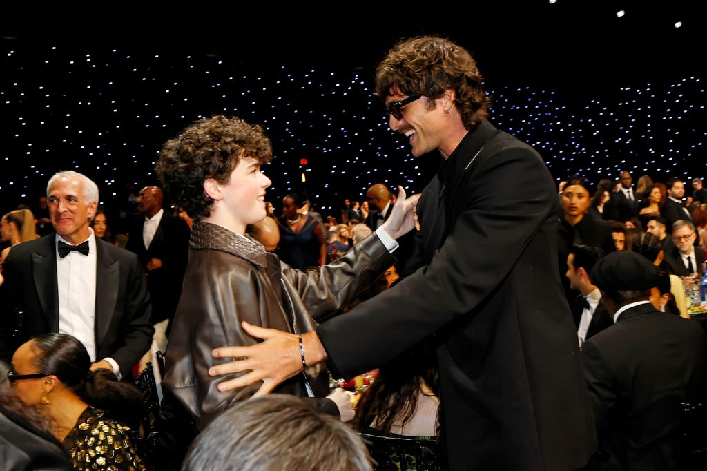 two actors greeting each other backstage awards show