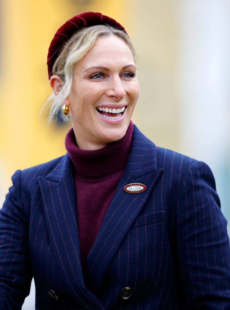 Zara Tindall in a blue jacket and red headband
