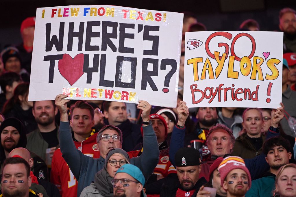 Fans hold up placards referring to Taylor Swift's boyfriend Kansas City Chiefs tight end Travis Kelce during the NFL game between Miami Dolphins and Kansas City Chiefs at the Waldstadion in Frankfurt am Main, western Germany on November 5, 2023