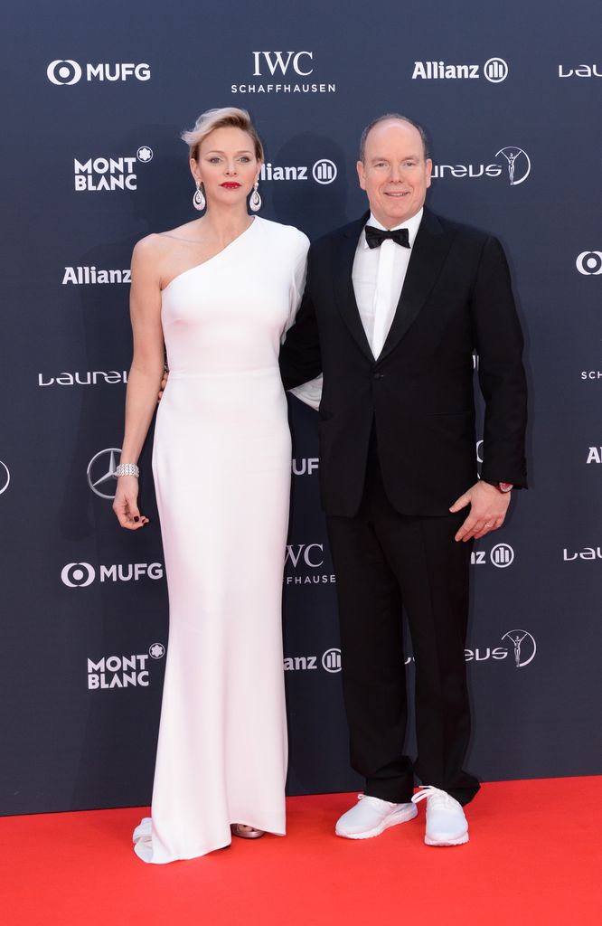 Prince Albert II of Monaco and his wife Charlene in white dress on red carpet 