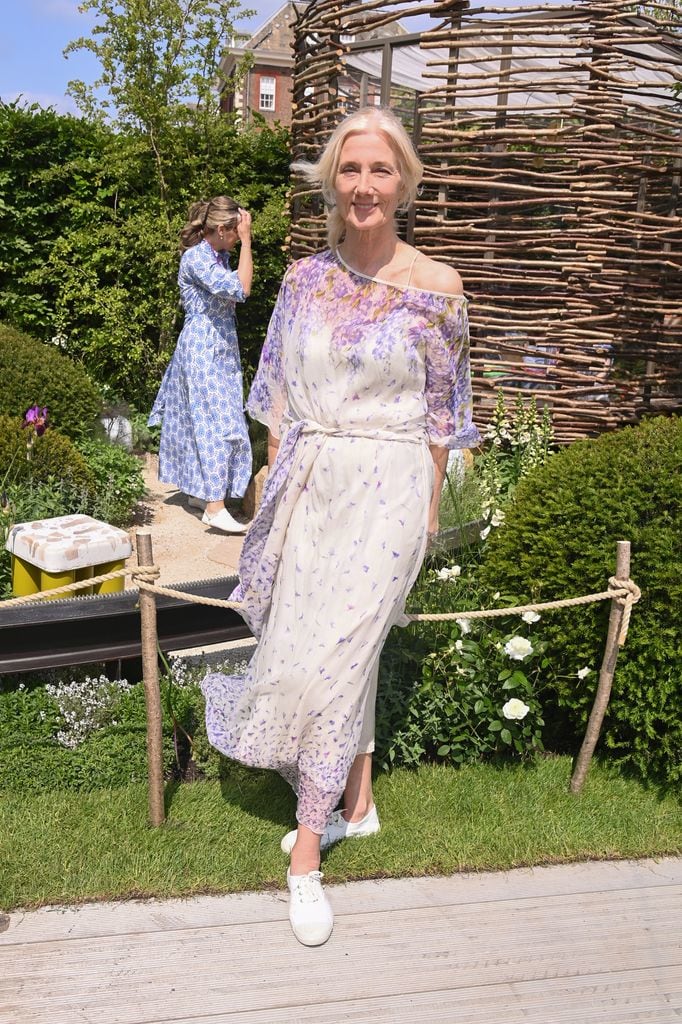 Joely Richardson wears a flowing off-shoulder floral dress with purple and cream tones at the Chelsea Flower Show 2025.