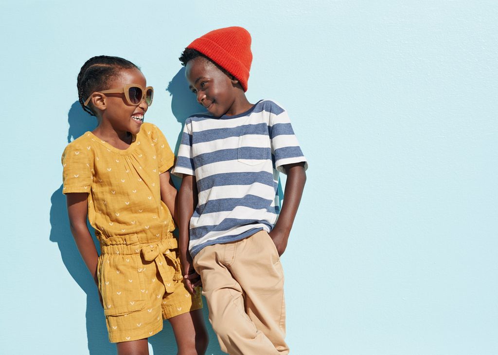 Portrait of boy & girl holding hands and laughing 