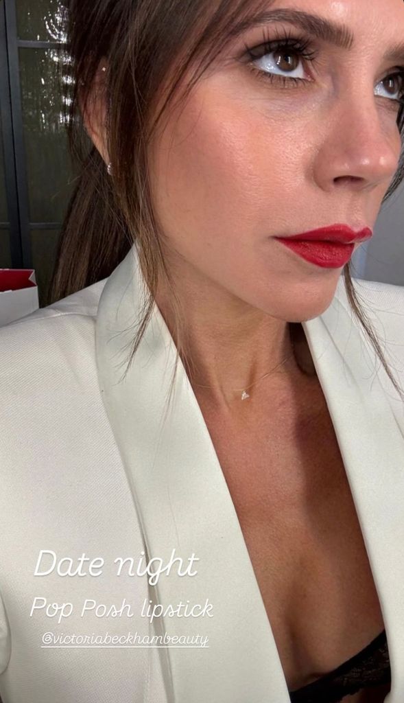 Victoria Beckham wearing a white suit and red lipstick