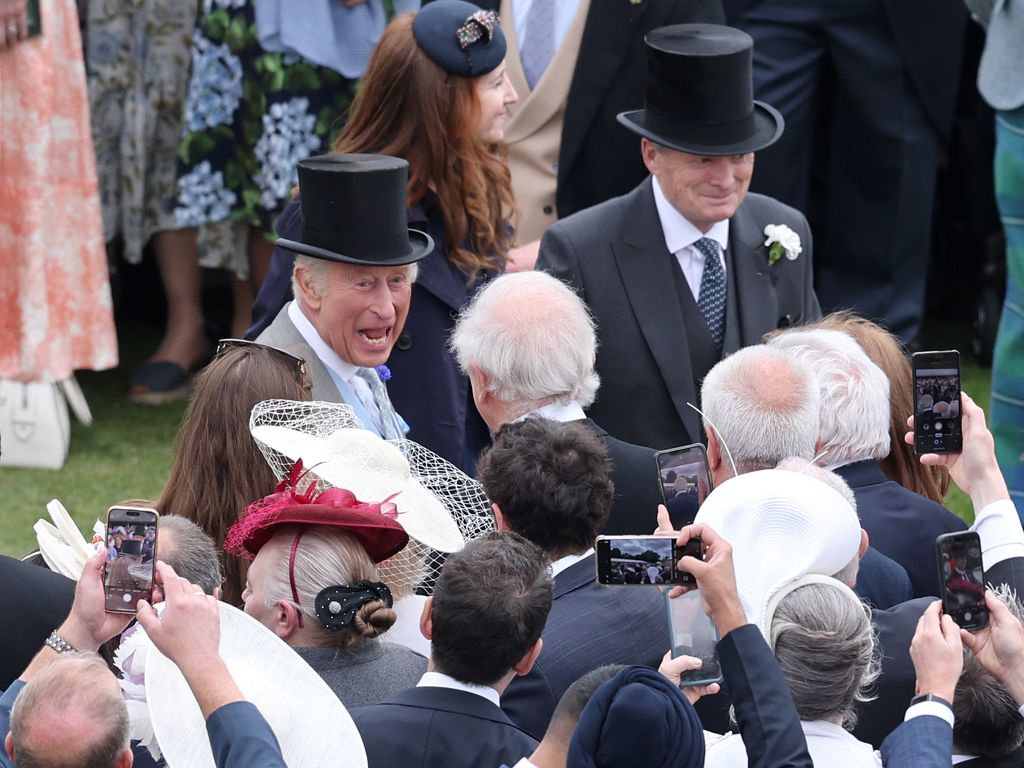 King Charles laughing with a group of guests