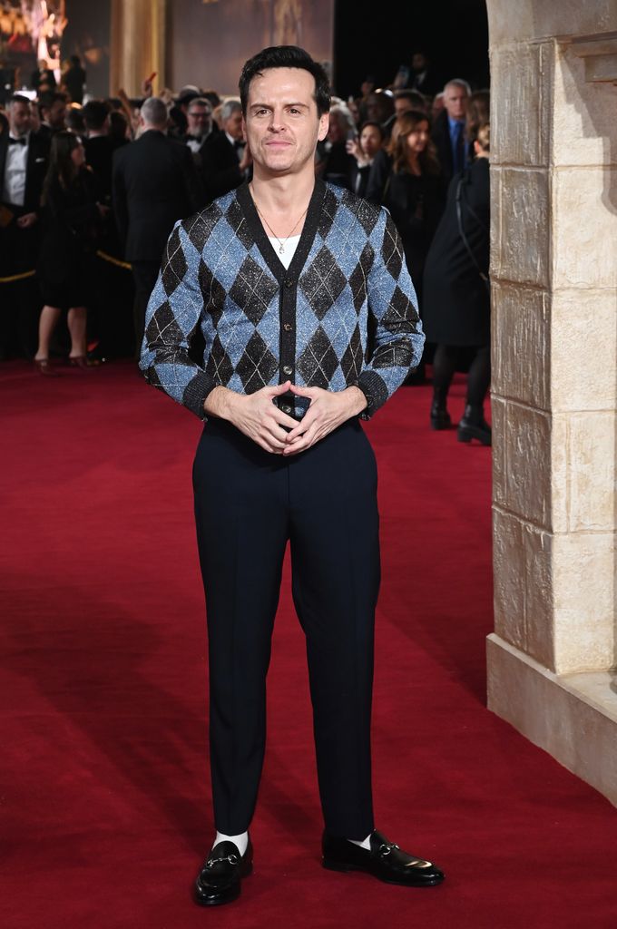 Andrew Scott in a diamond jumper and navy trousers