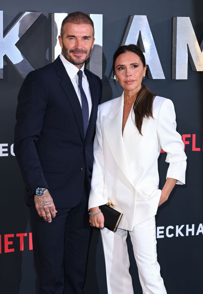 David Beckham in blue suit with Victoria Beckham in a white suit