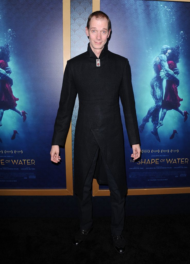 Doug Jones se tient devant deux affiches du film The Shape of Water lors de la première du long métrage.