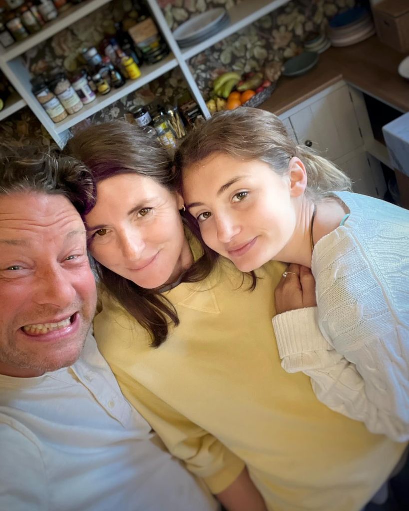father and mother posing for selfie with daughter 