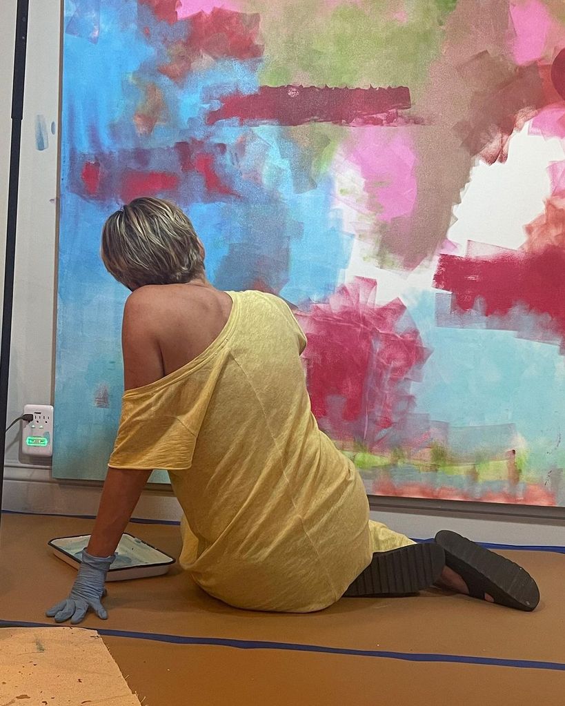 Sharon Stone sitting in front of one of her paintings in a photo shared on Instagram