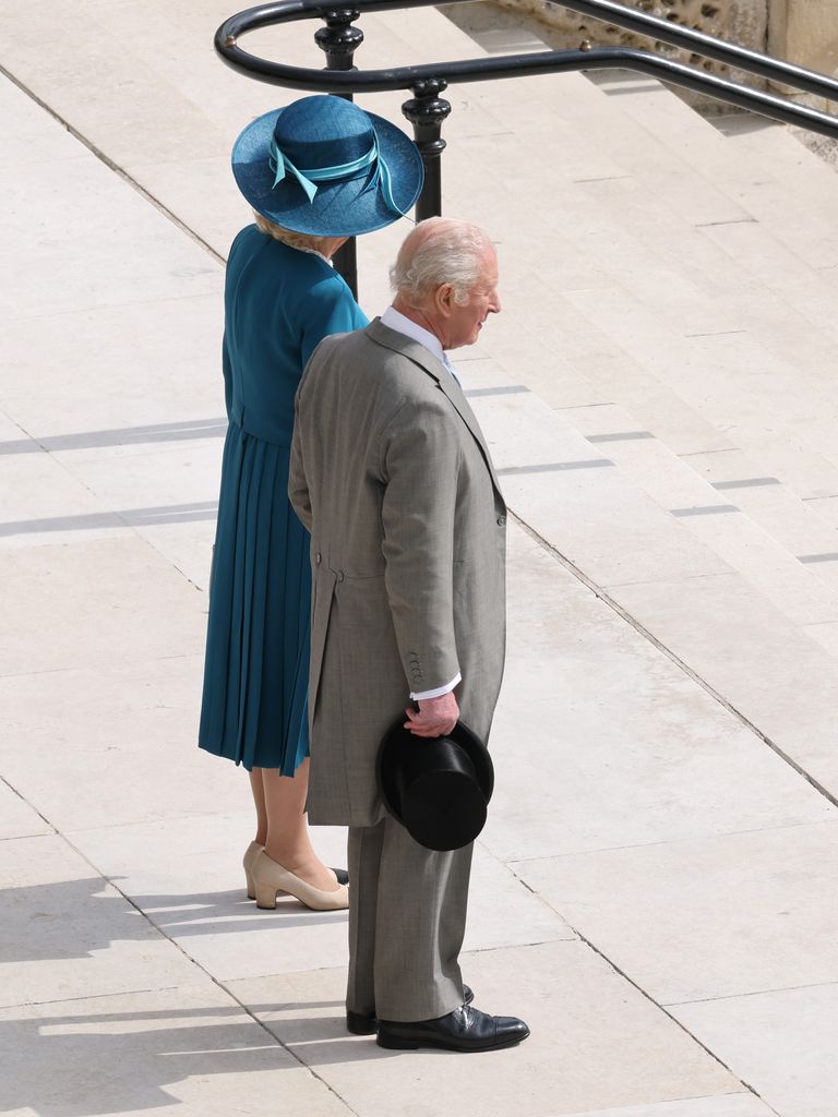 King Charles and Queen Camilla stand at the top of steps