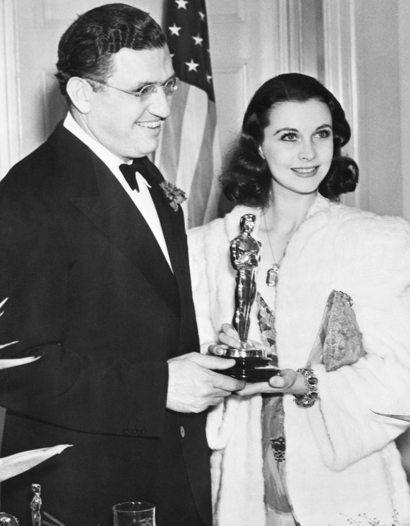 (Original Caption) 3/2/1940-Hollywood, California- Vivien Leigh, chosen as the actress who gave best screen performance in 1939, gets her gold "Oscar" at twelfth annual Academy Awards banquet in Hollywood. David O. Selznick, producer of "Gone With the Wind" admires his star's trophy. The statuette was given the auburn-haired british actress for her rendition of the role Scarlett O'Hara in "Gone With the Wind."