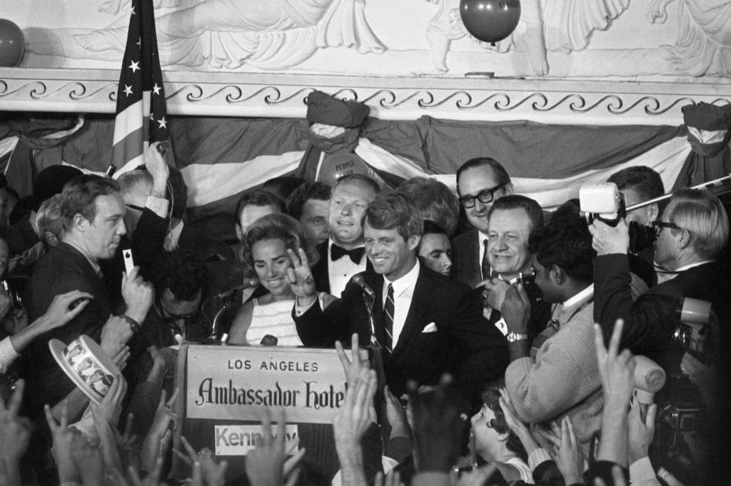 Sen. Robert Francis Kennedy (D- N.Y.), his wife Ethel standing behind him, gives victory sign to huge crowd at the Ambassador Hotel June 5th, prior to making victory speech after winning the California primary. A few minutes later, the 42 year old Senator was brought down by an assassin's bullets upon entering a hotel corridor, 1968