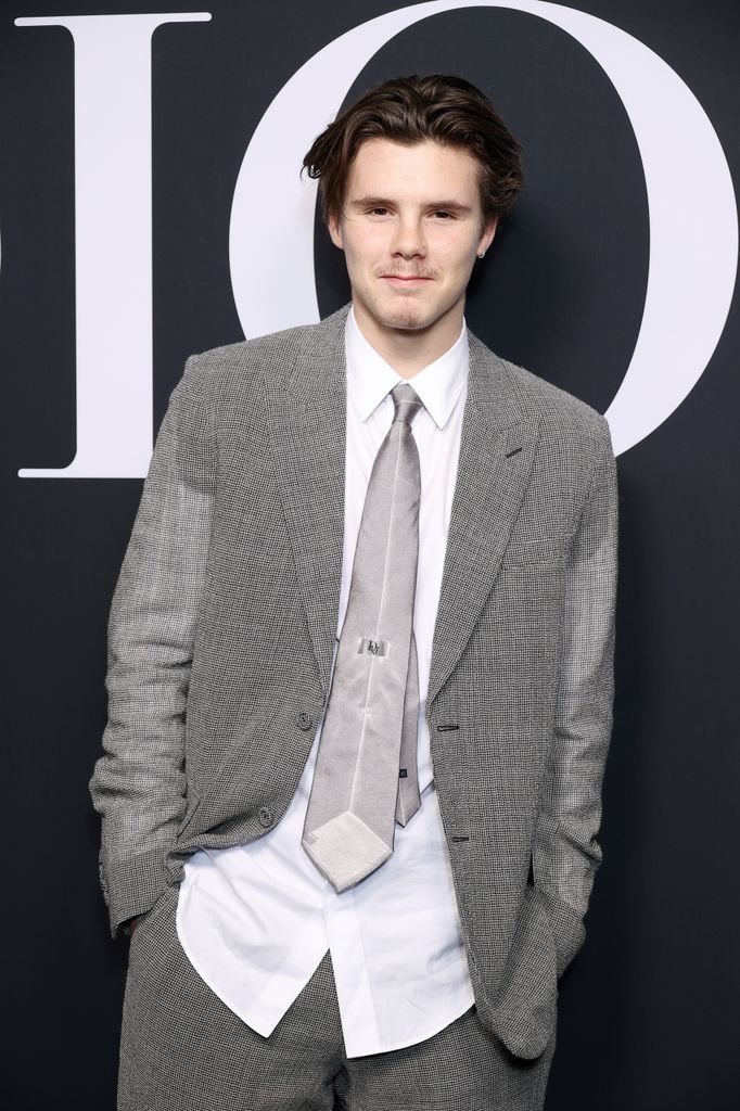 Cruz Beckham wearing a grey suit