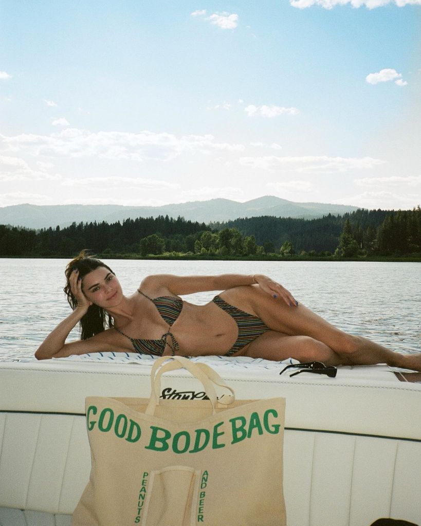 Kendall Jenner in brown two-piece bikini posing by water