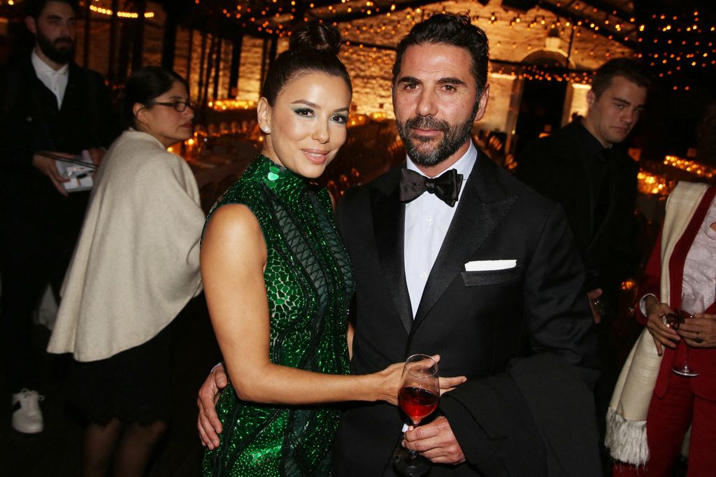 Eva Longoria and her husband Jose Baston posing at a formal dinner